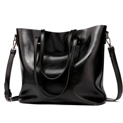 Black oil leather tote bag with square shape, zipper top, soft handle, and internal pockets for winter use