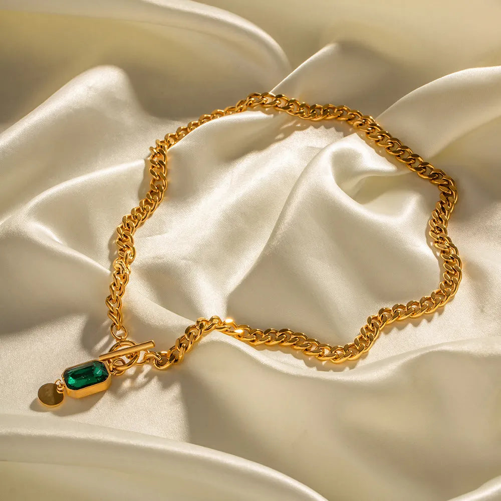 Gold titanium steel necklace with geometric pendant containing emerald zircon stone