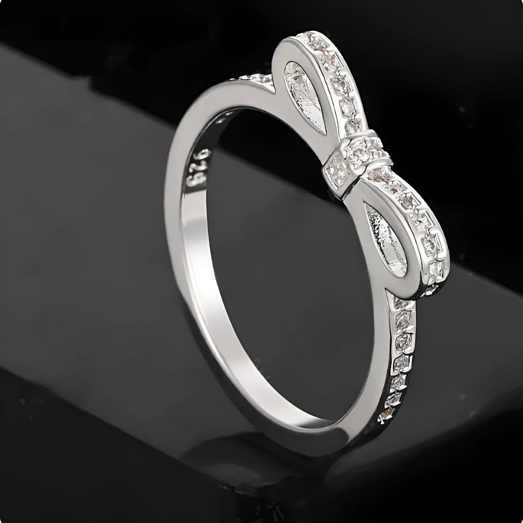 Silver couple ring with a bow shape set with rhinestones and zircon crystals.