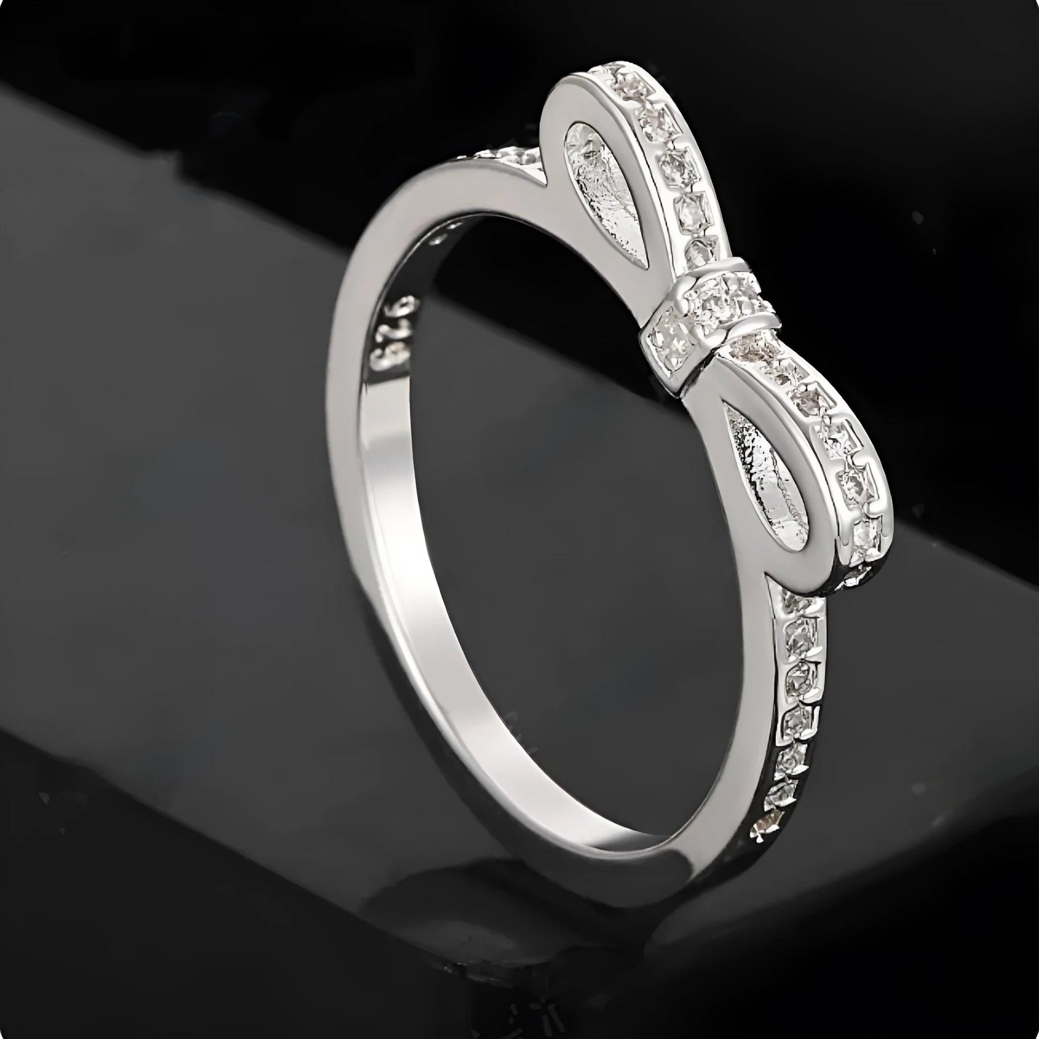 Silver couple ring with a bow shape set with rhinestones and zircon crystals.