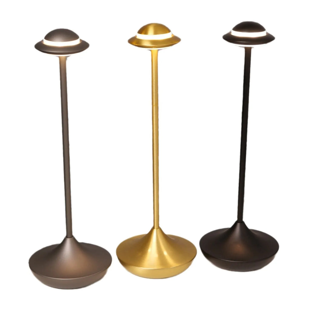 Metallic UFO-shaped rechargeable table lamp with touch controls in black finish on a wooden desk.