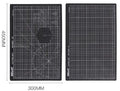 Green self-healing A3 cutting mat with centimetre grid lines on a wooden desk.