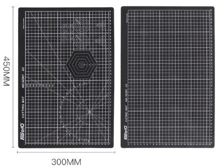 Green self-healing A3 cutting mat with centimetre grid lines on a wooden desk.