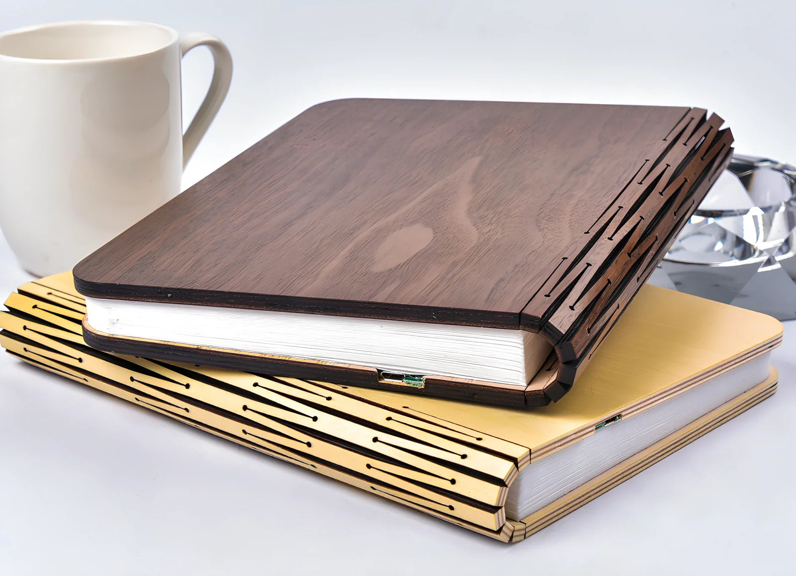 Wooden folding LED book light in walnut finish, open to 360 degrees showing warm white illumination on Tyvek pages, 21.5cm size