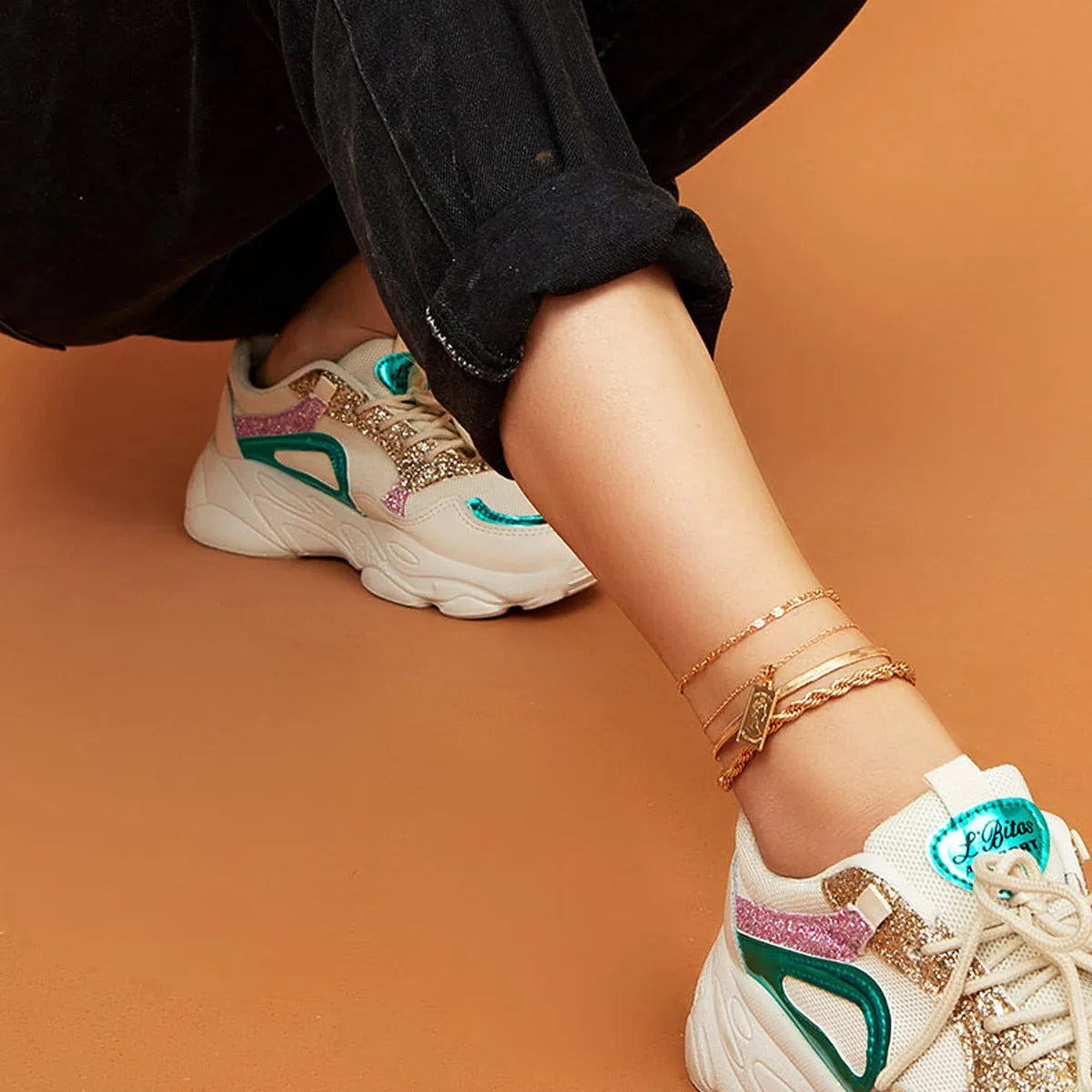 Golden geometric alloy electroplated anklet on white background