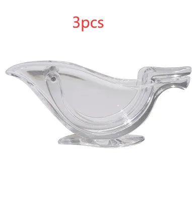 Transparent acrylic manual lemon juicer in the shape of a bird on a kitchen counter.