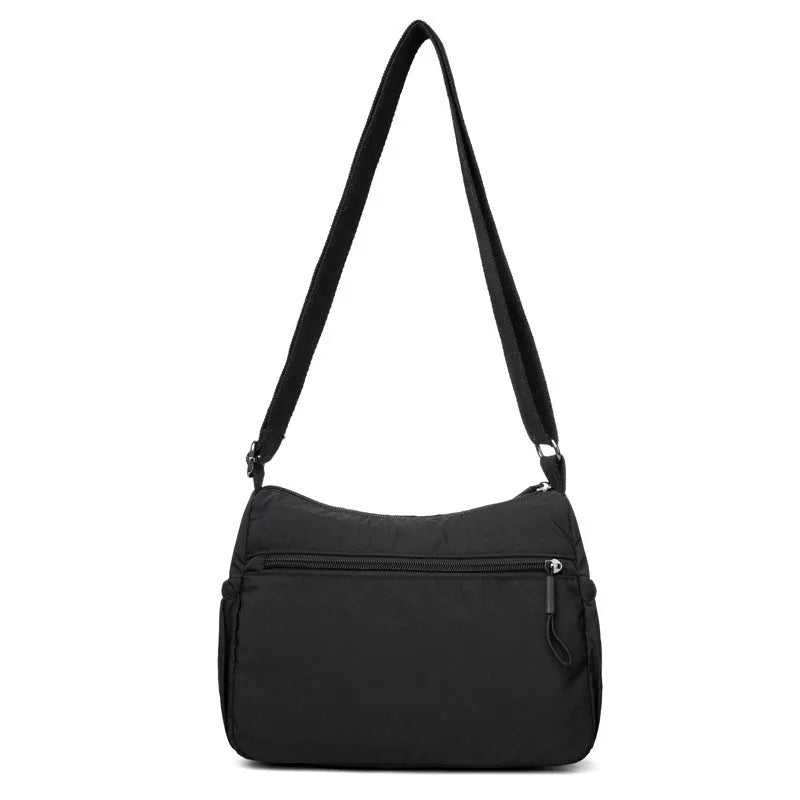Grey water-repellent nylon crossbody bag showing three-dimensional pockets and a single shoulder strap.
