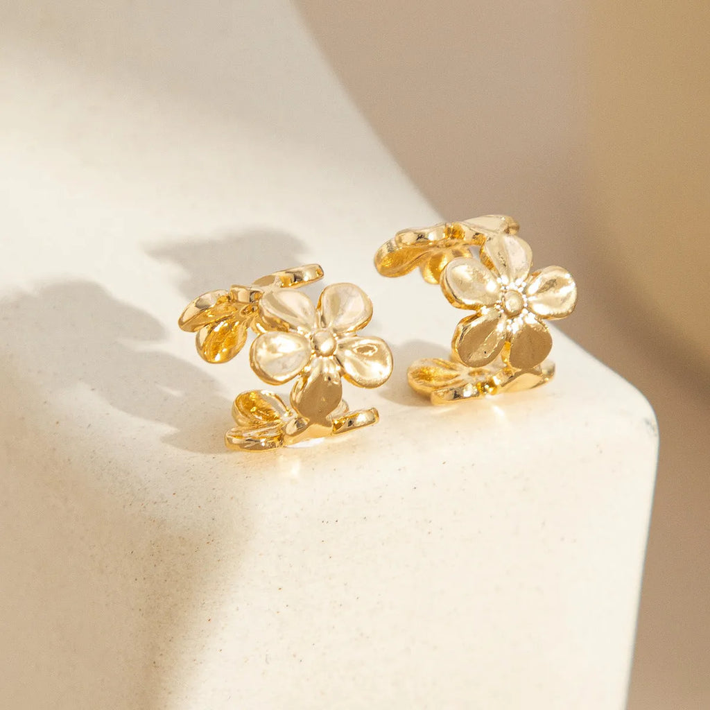 A pair of gold drop earrings featuring a detailed starfish and conch design on an alloy base.