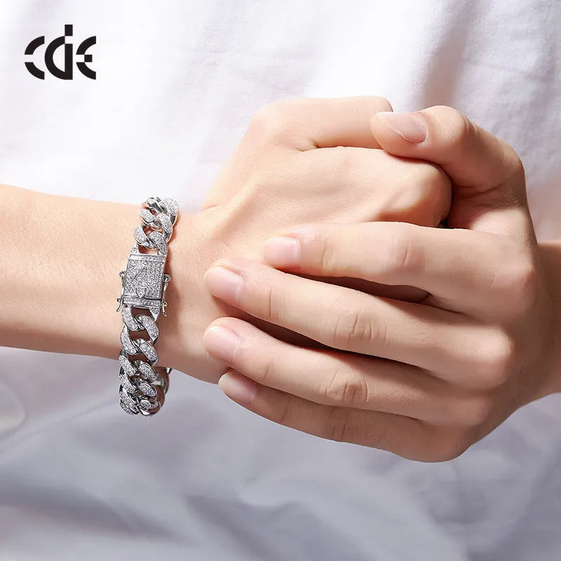 Men's Cuban chain bracelet with gold finish and geometric zircon pendant on a flat surface
