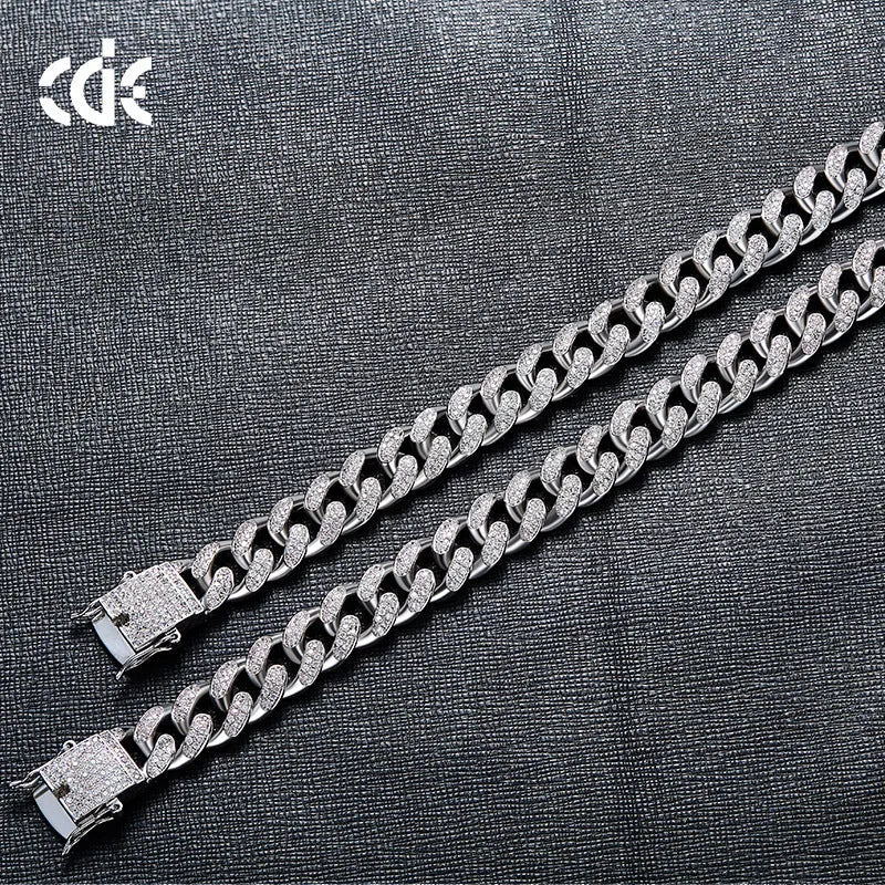 Men's Cuban chain bracelet with gold finish and geometric zircon pendant on a flat surface
