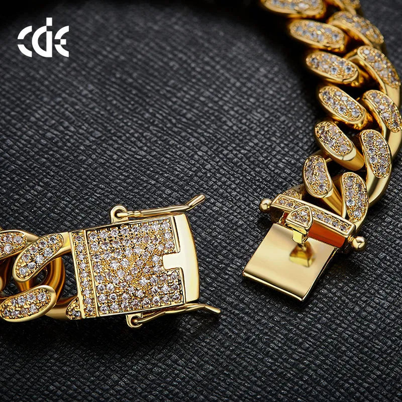 Men's Cuban chain bracelet with gold finish and geometric zircon pendant on a flat surface