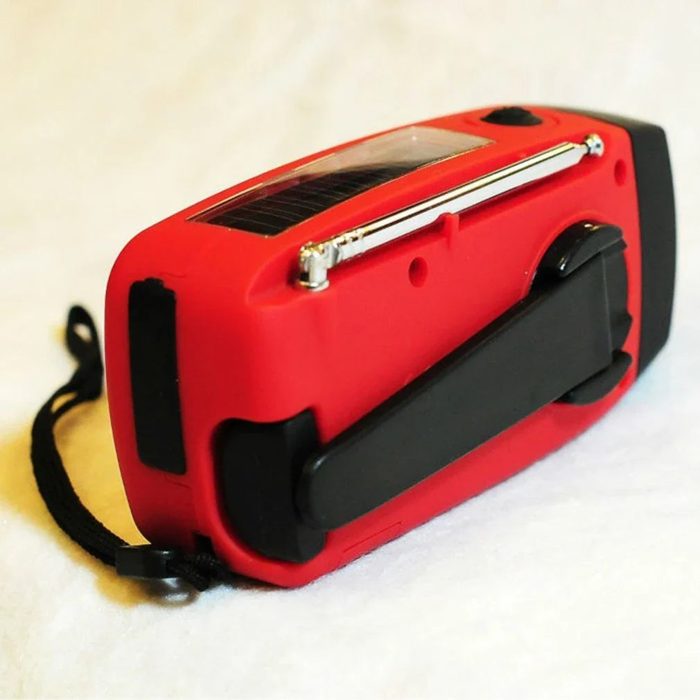 Versatile solar and hand-crank powered radio, flashlight, and USB charger with rugged ABS construction and dual charging capabilities