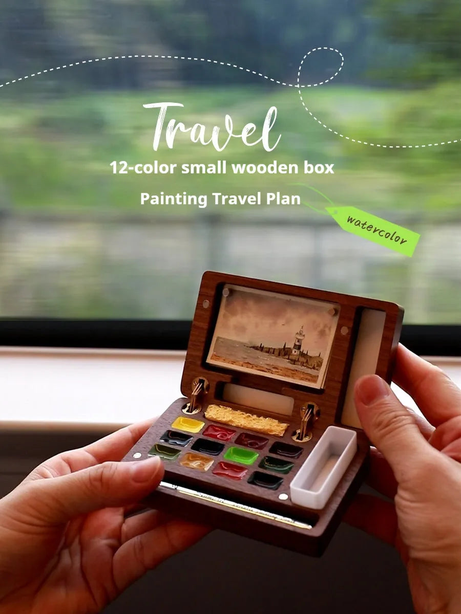 Mini walnut-finish wooden watercolour paint box open to show internal compartments with pigment pans.