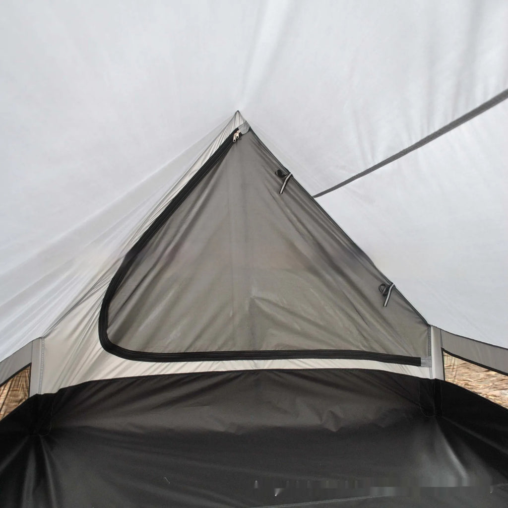 Lightweight brown A-line hiking tent set up with hiking cane supports in outdoor setting