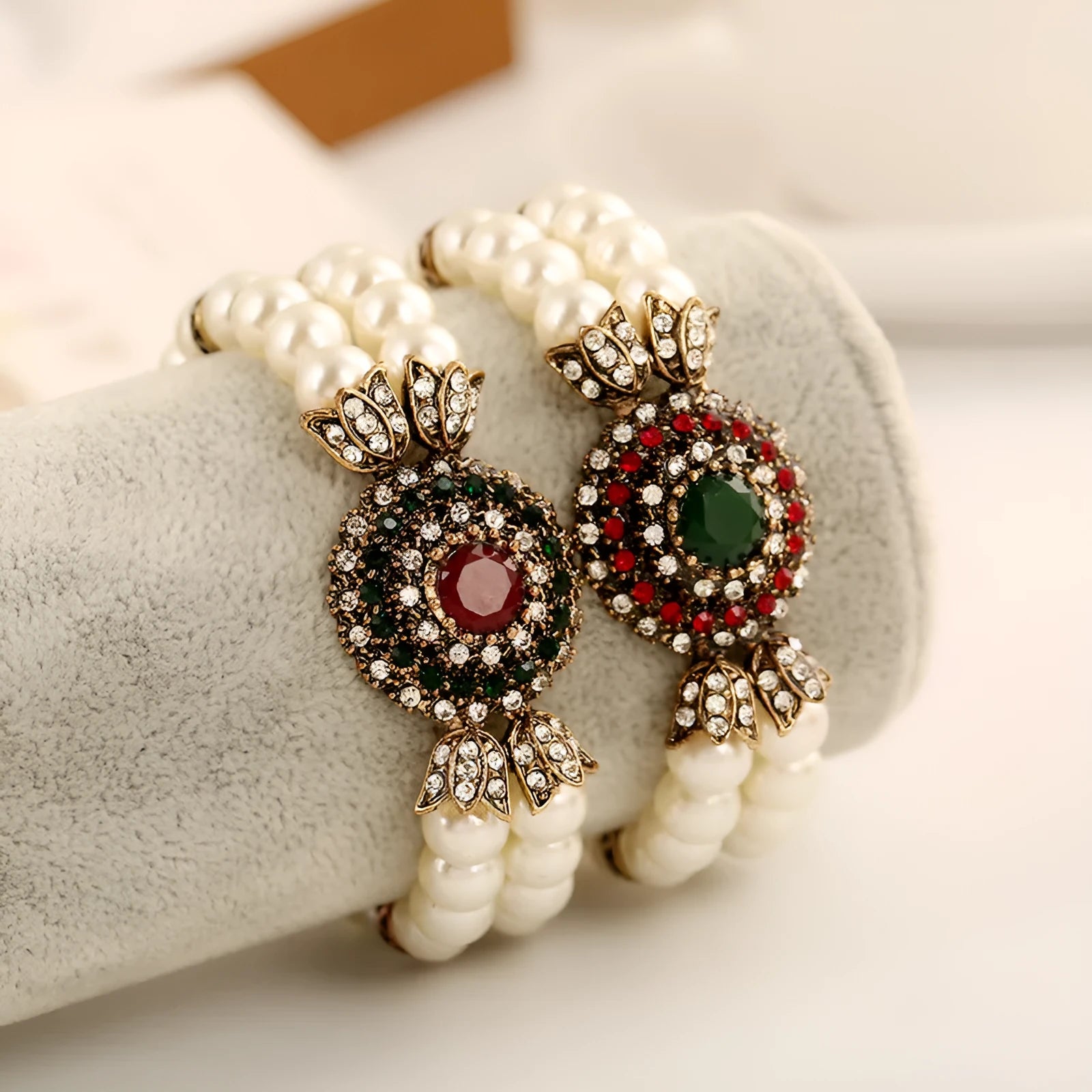 Luxury pearl bracelet in green and red alloy metal on display