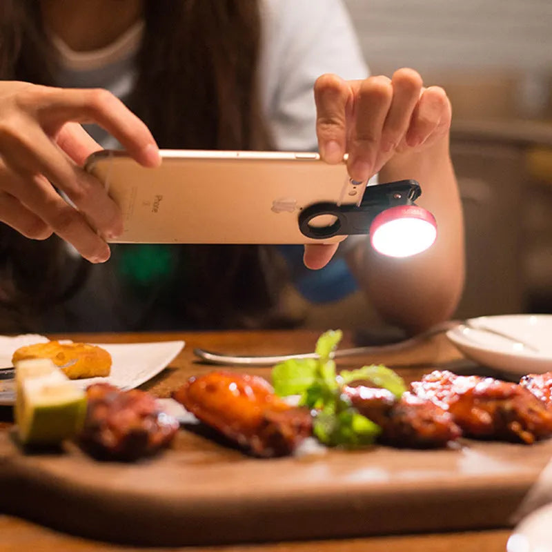 External smartphone camera lens with wide-angle capability and colourful LED lights attached to mobile phone