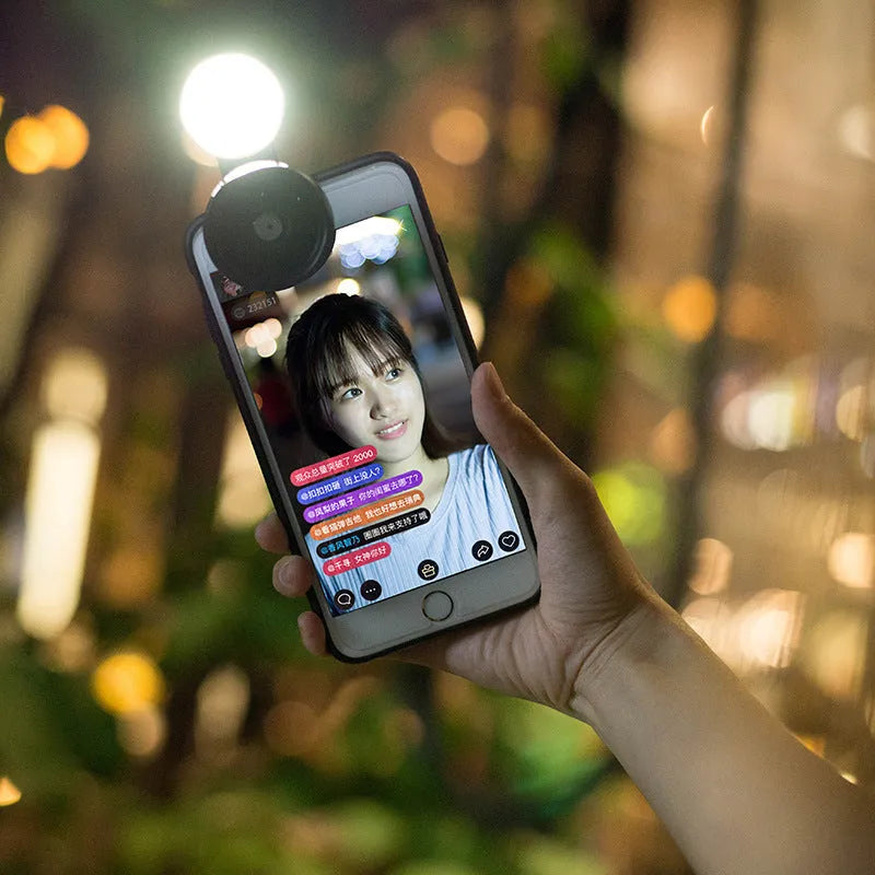 External smartphone camera lens with wide-angle capability and colourful LED lights attached to mobile phone