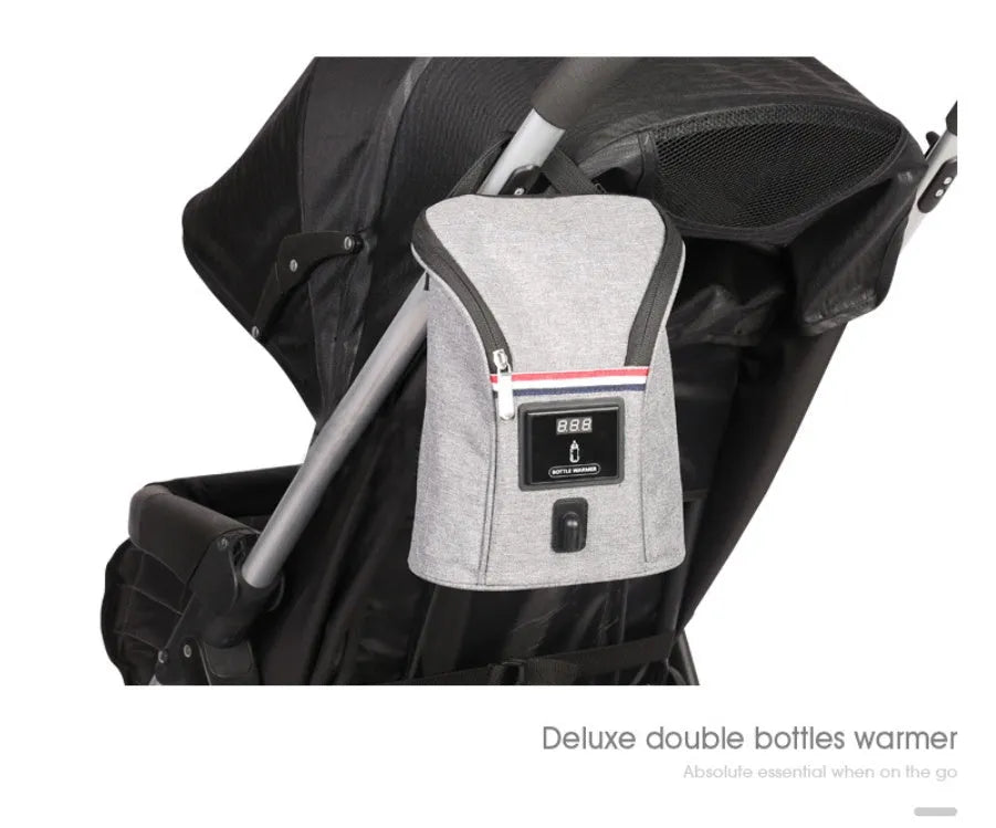 Grey Oxford cloth portable baby bottle warmer with electronic display and car charger, shown next to two baby bottles.