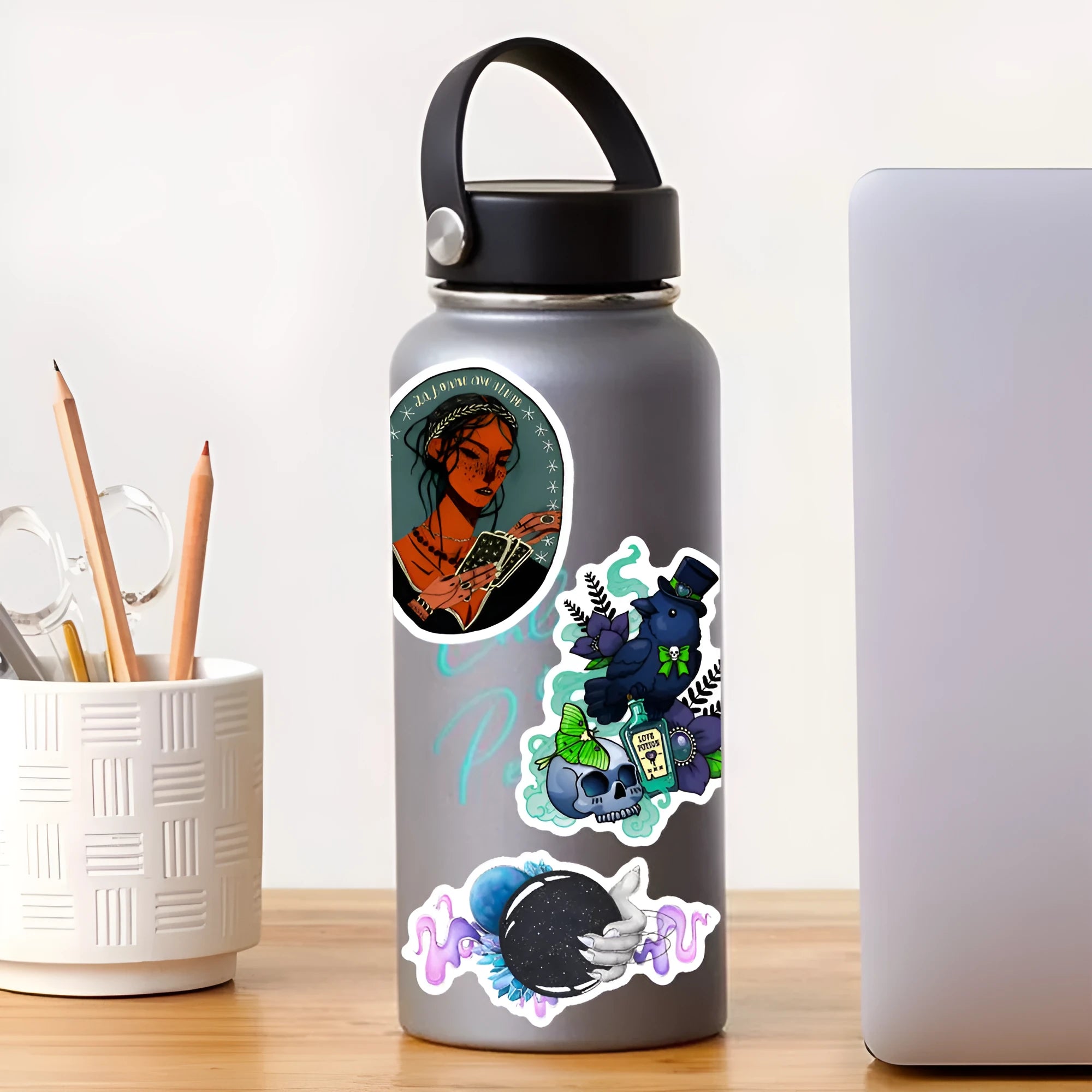Pack of 50 colourful waterproof PVC stickers for laptops and skateboards on a smooth surface.