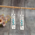 Long silver geometric drop earrings with inlaid turquoise details on a retro-style zinc alloy setting.