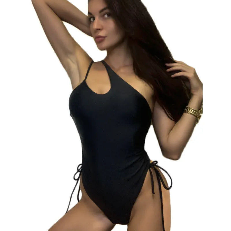 Black tight-fitting women's dress with sloping shoulder design and lacing detail