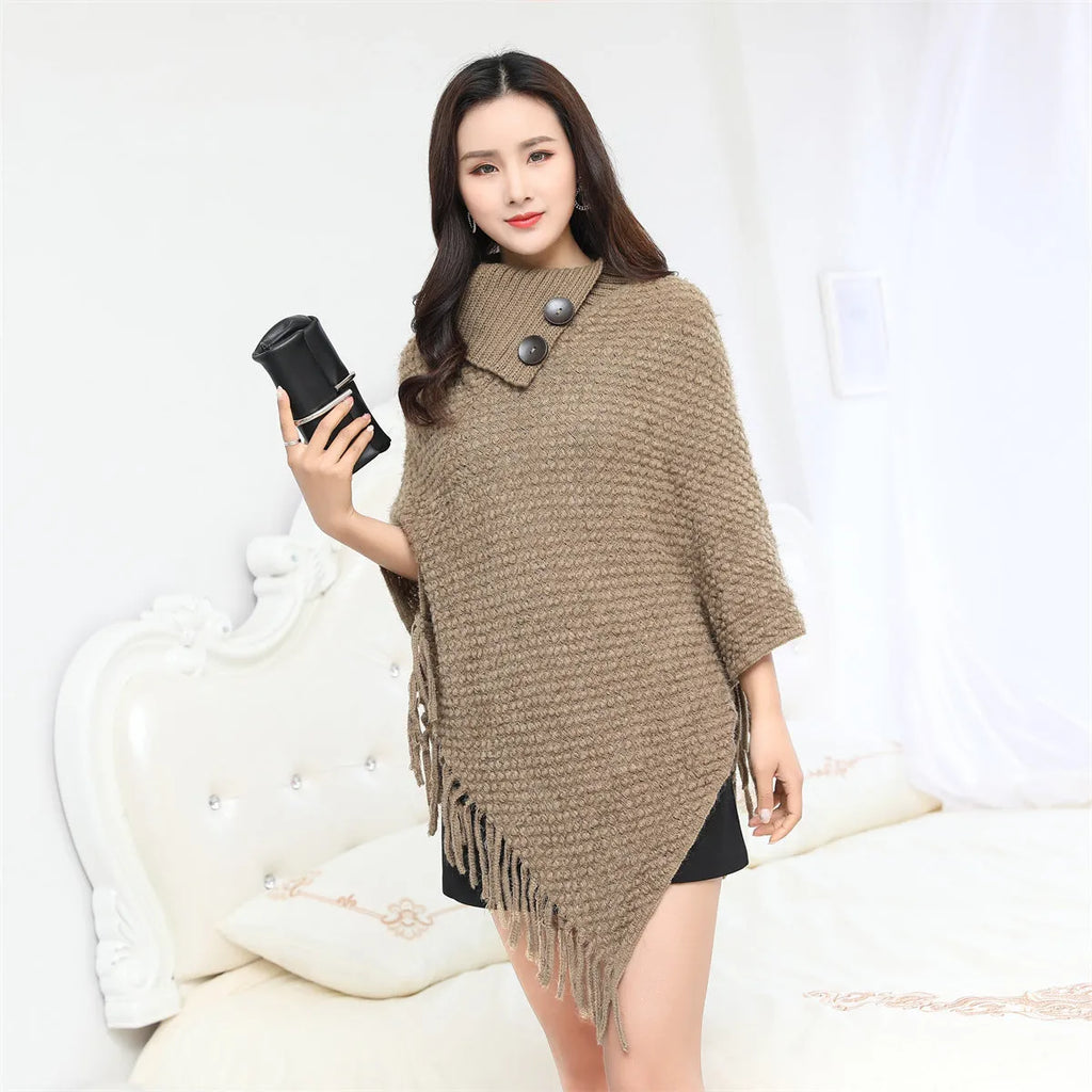Sleeveless dot pattern knit cloak poncho in apricot colour, laid flat.