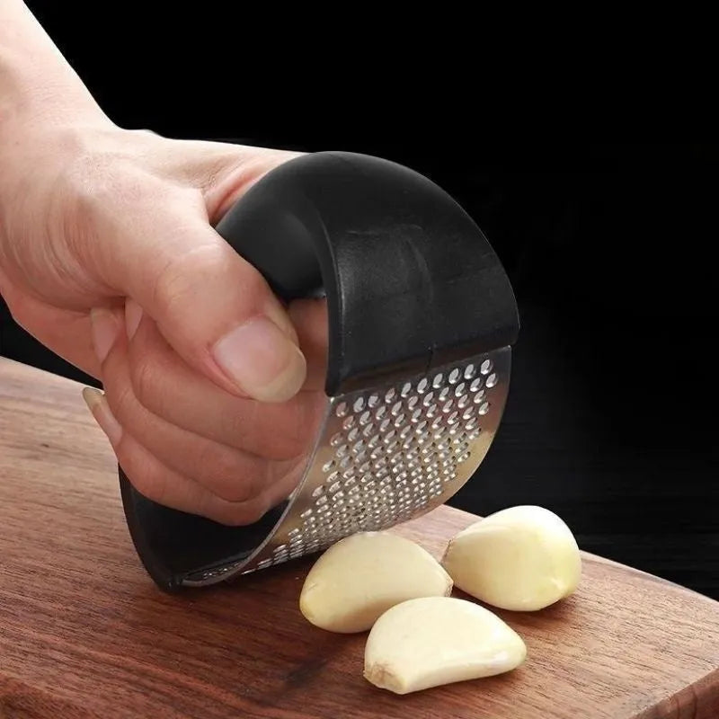 Stainless steel garlic press with curved ergonomic design and non-slip handle in assorted colours.