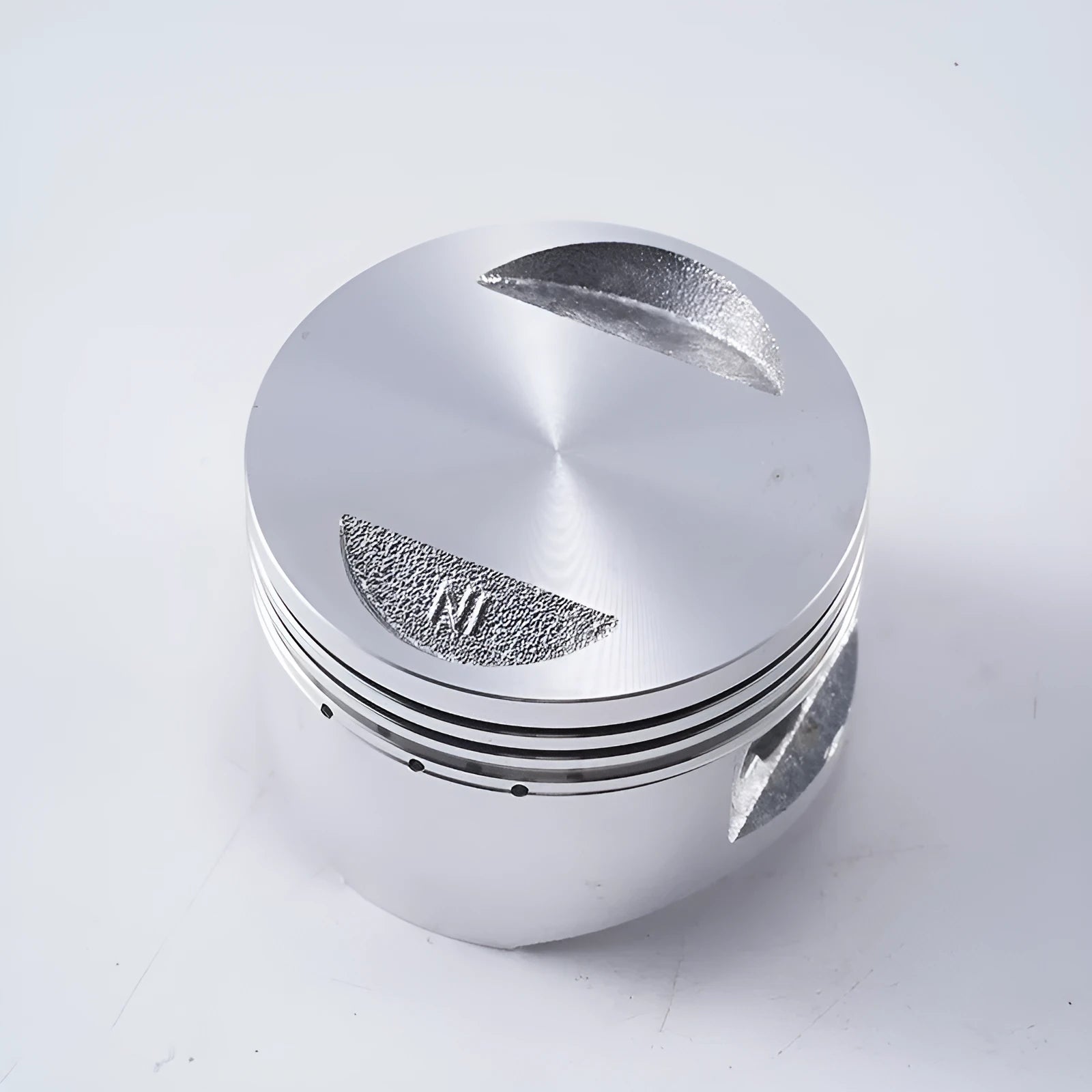 Motorcycle engine piston kit showing aluminium piston, steel oil ring, and pin for 57.4mm cylinder