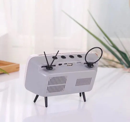 Retro TV mini portable Bluetooth speaker in blue with circular grille and compact 18x8x2.5cm size on a wooden desk
