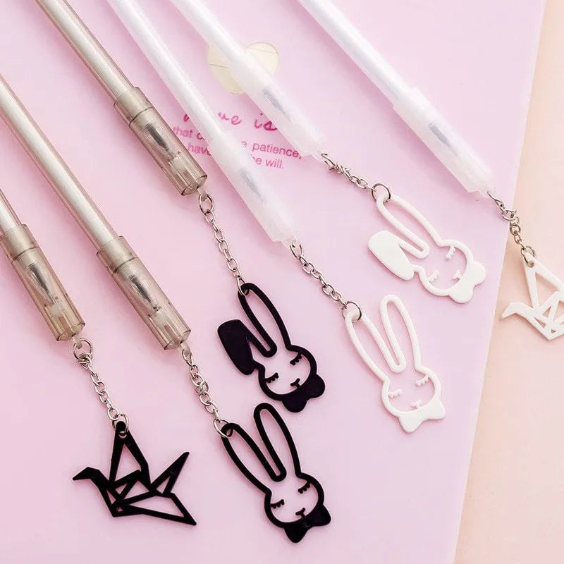 White and black gel pen with removable paper crane and rabbit pendant charms on a 17cm plastic body