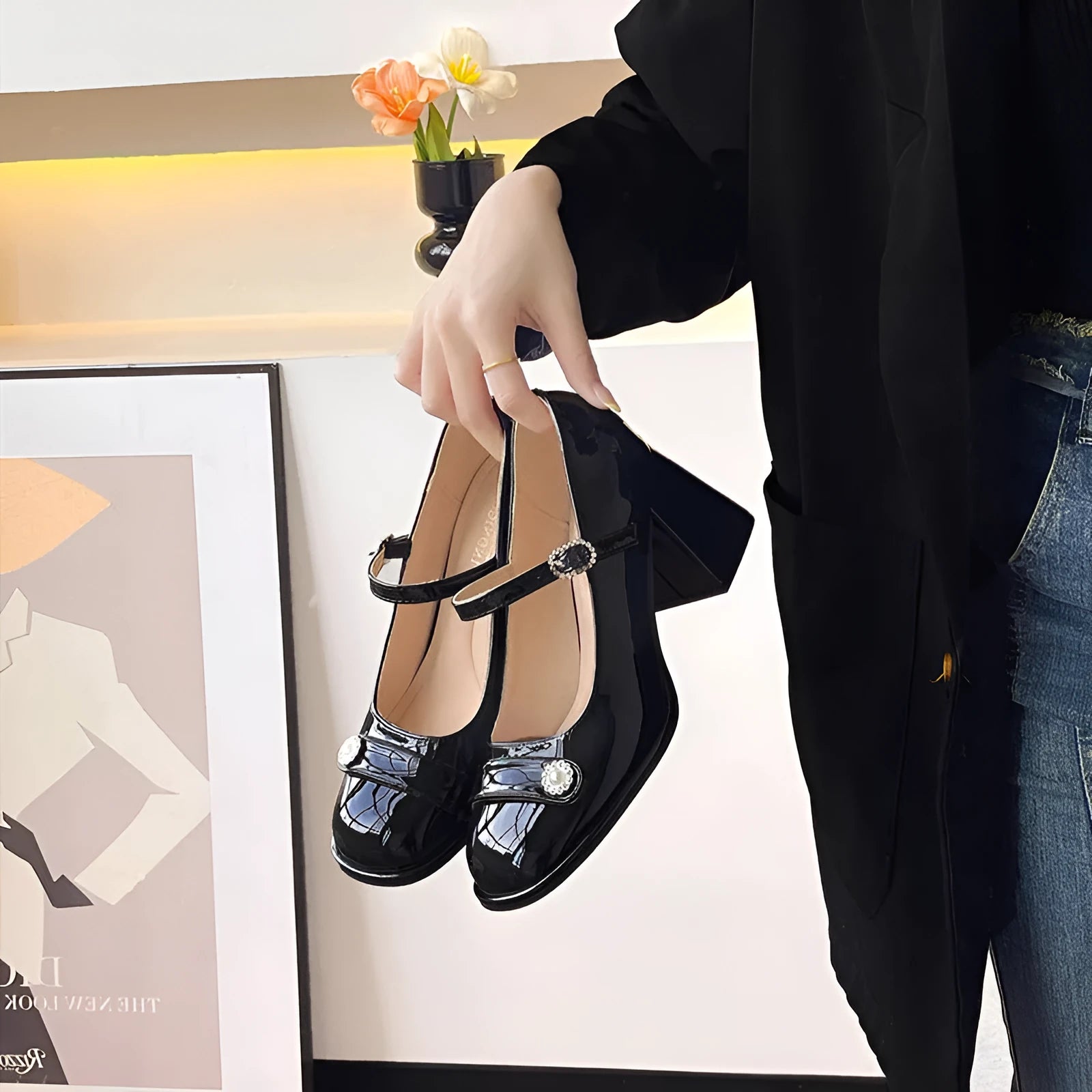 Women's black patent leather chunky heel court shoe with round toe and buckle fastening.