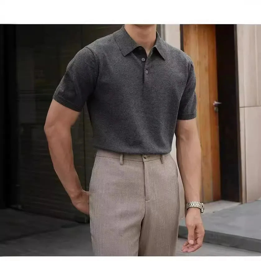 Men's black polo shirt with knitted collar and short sleeves laid flat.