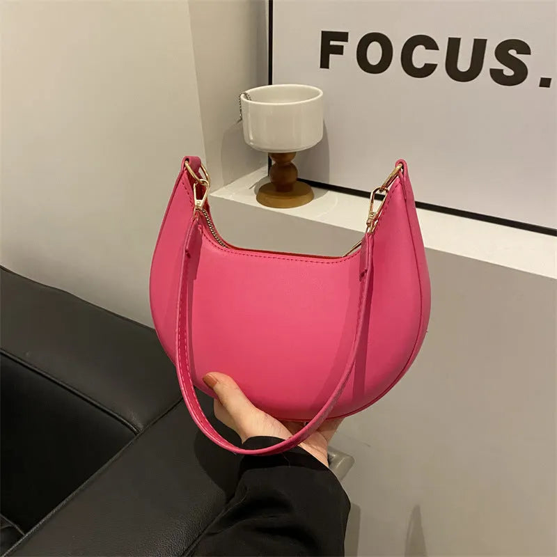 Round women's underarm bag in PU material showing sewing line detailing and internal phone compartment