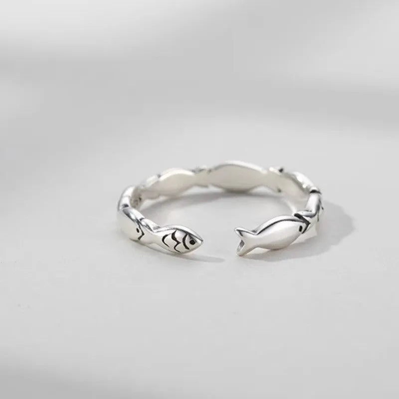 Close-up of a women's adjustable S925 sterling silver ring featuring a detailed fish (carp) design.