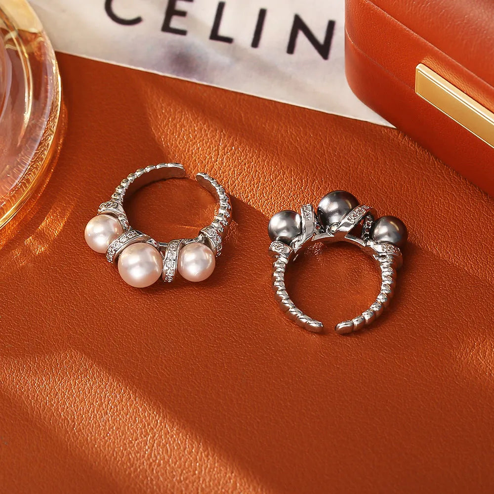 Real gold plated copper open-end ring with round pearl in geometric setting, grey colour, on a neutral background