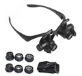 Double eye LED magnifier glasses with headband and 4 interchangeable lenses on black background