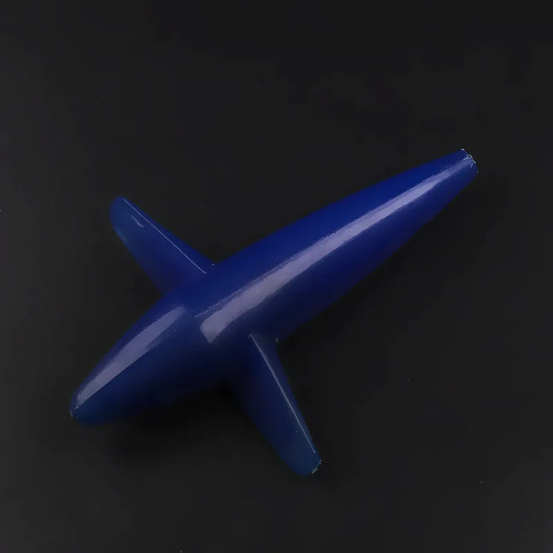 Multi-colour aircraft sea fishing lure in blue, green, and purple on a sandy beach