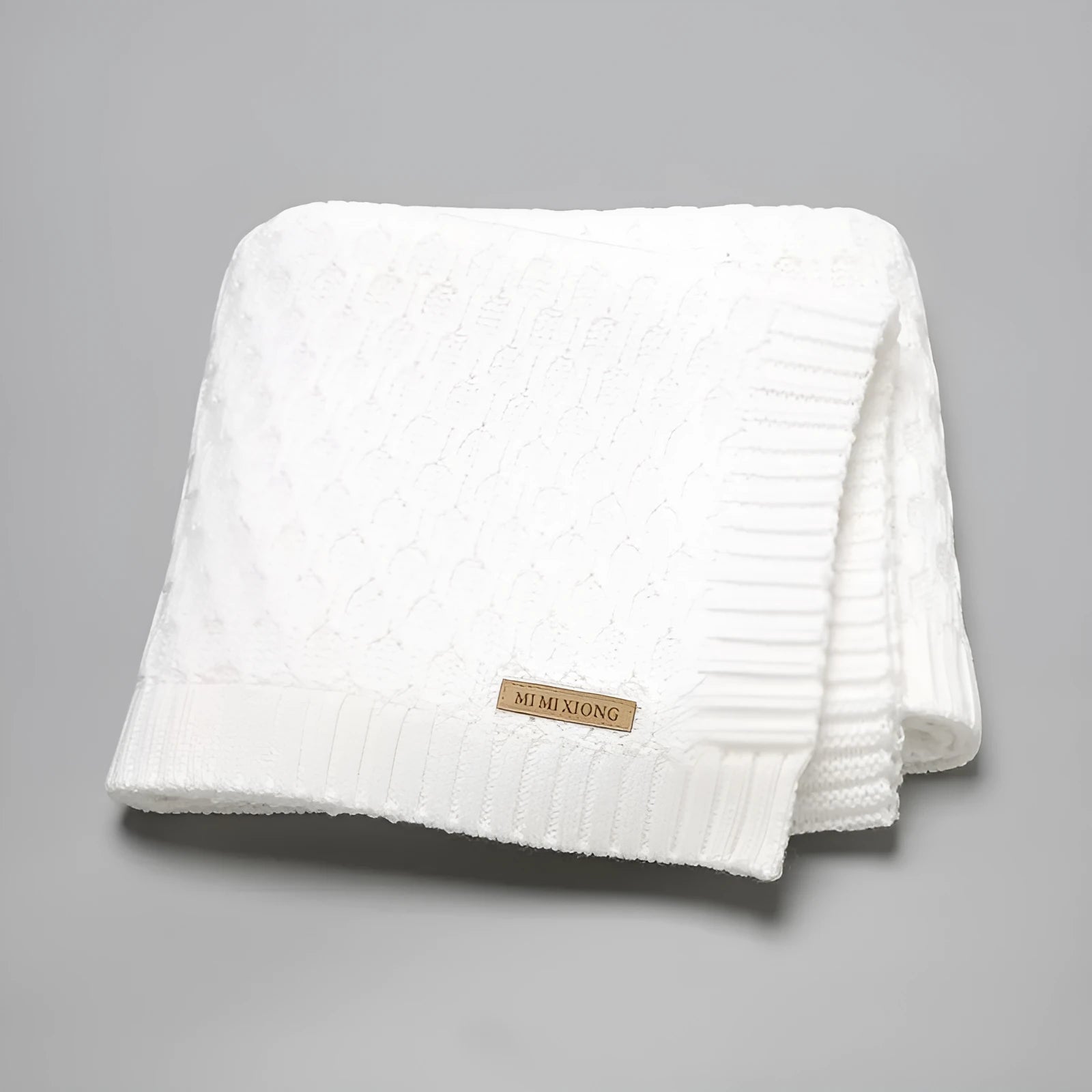 Solid colour acrylic infant blanket with raised lines, shown in a light green colour.