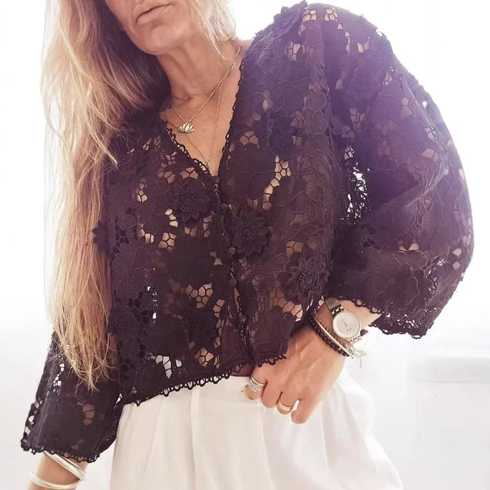 Loose fit white lace cardigan with black three-dimensional flower trim and a V-neck.