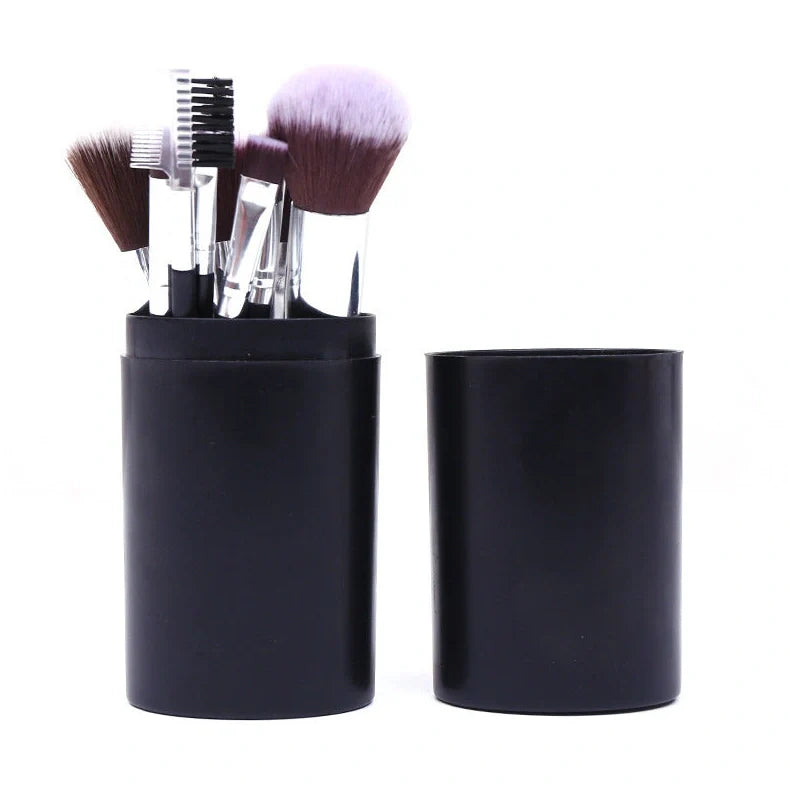 12 makeup brushes with pink handles and black bristles arranged in white storage bucket