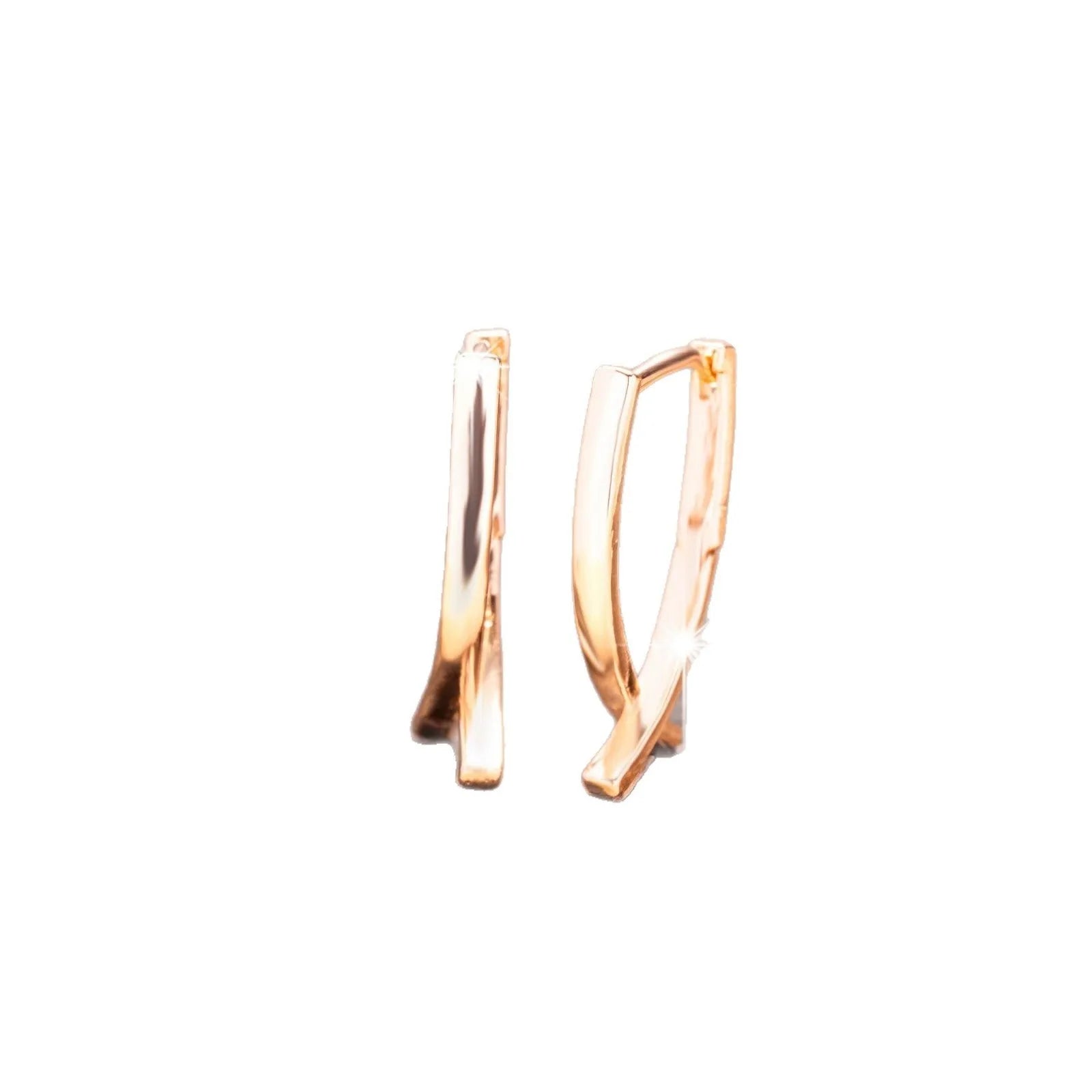 A pair of rose gold cross shaped drop earrings on a plain background.