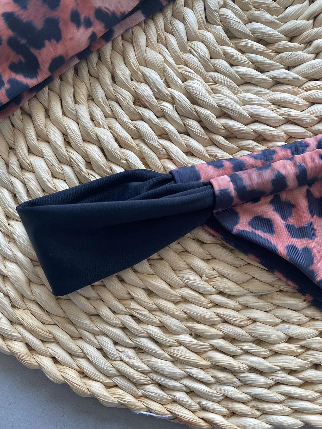 Black women's bikini with leopard print tube top and matching split T-back pant.
