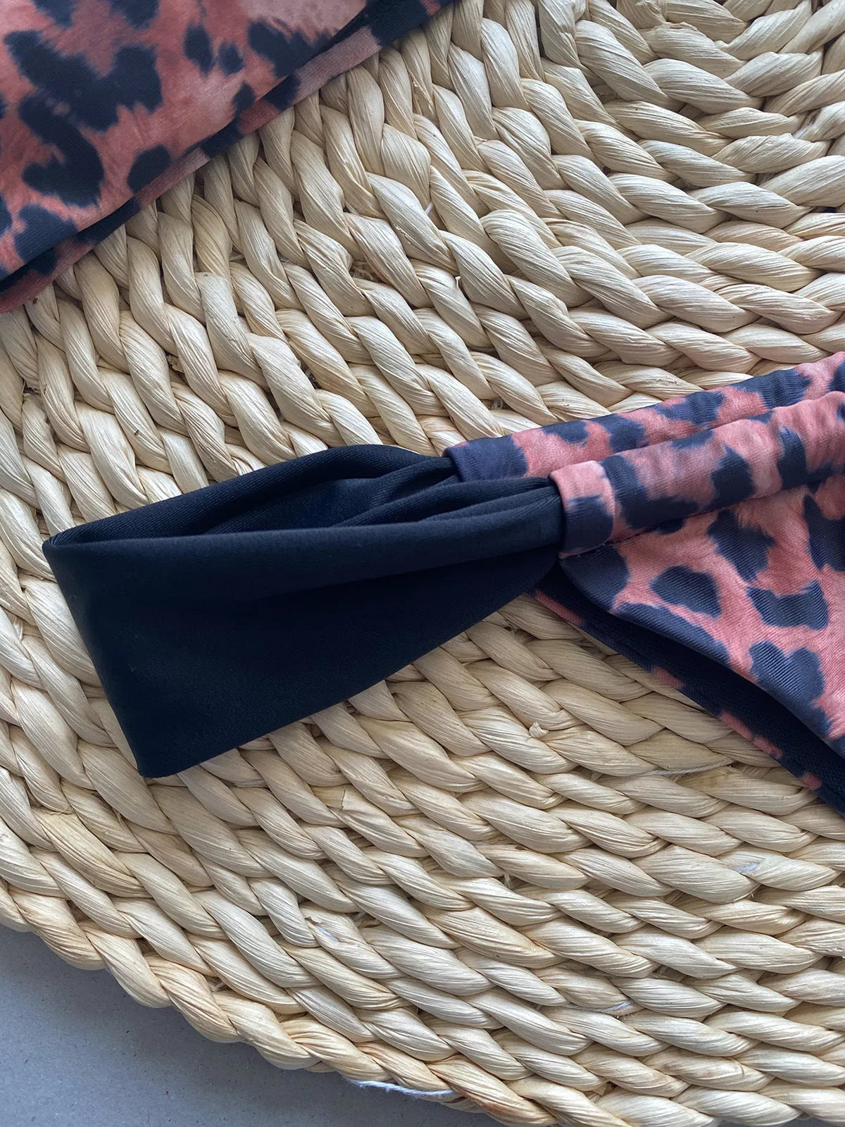 Black women's bikini with leopard print tube top and matching split T-back pant.