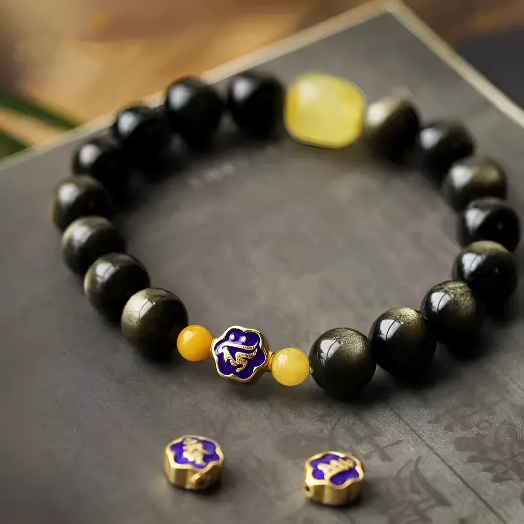 Golden obsidian bracelet with carved zodiac symbols on geometric beads
