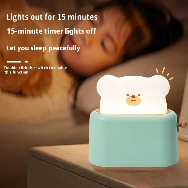 Bread bear shaped silicone night light with warm yellow glow on a desk