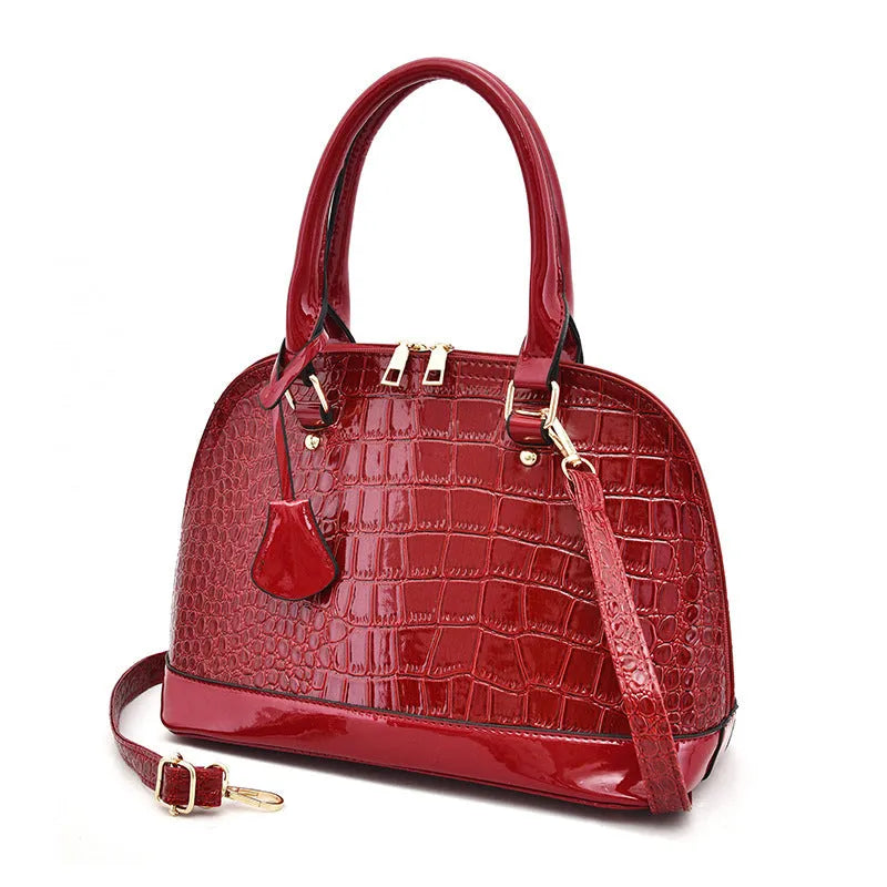 Shiny black PU crossbody shoulder bag with a structured shell shape.