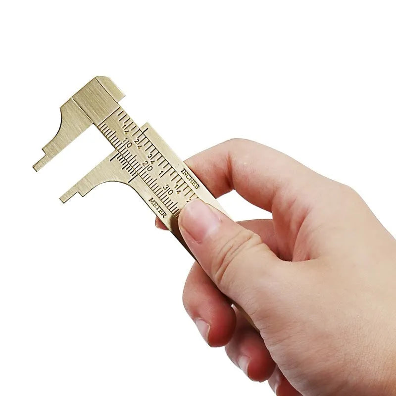 Double scale mini copper caliper with brass body, 100mm range, showing dual metric and imperial scales