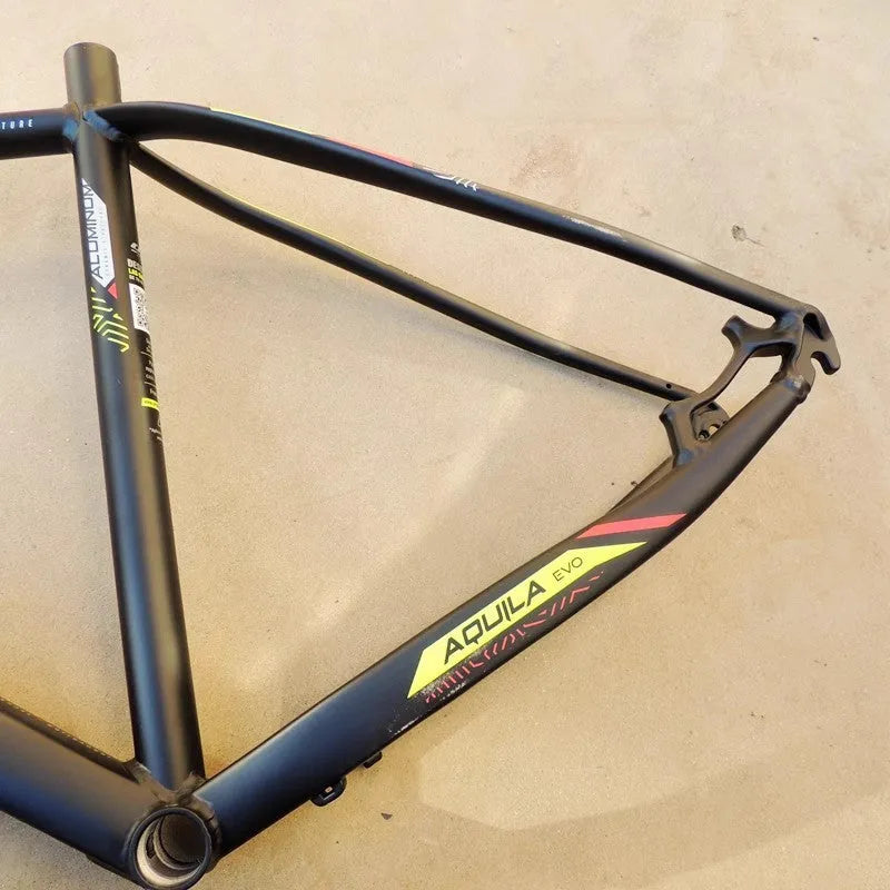 Black green 29 inch aluminium mountain bike frame showing internal cable routing ports and disc brake mount.
