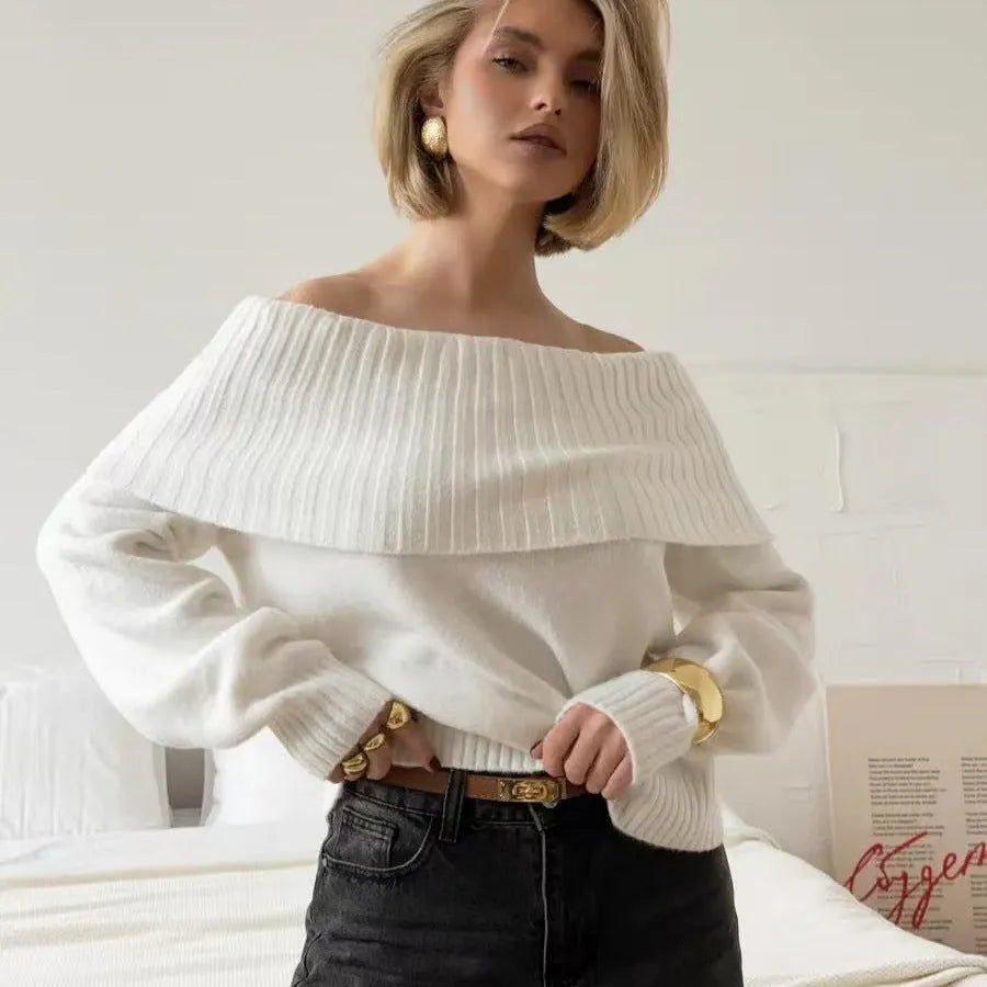 Grey off-the-shoulder acrylic sweater with a textured 3D pattern on a hanger.