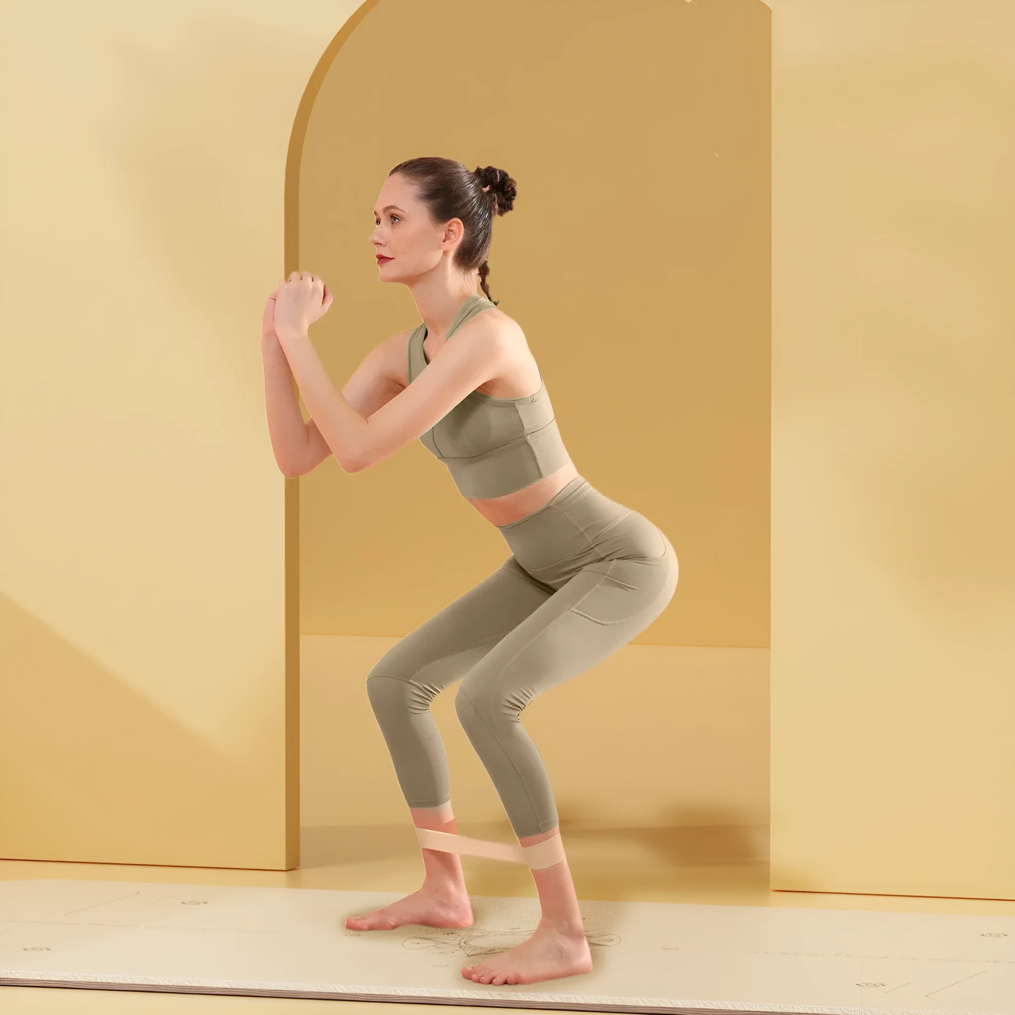 Colour-coded elastic resistance band showing pink, orange, beige, and green options for fitness and yoga